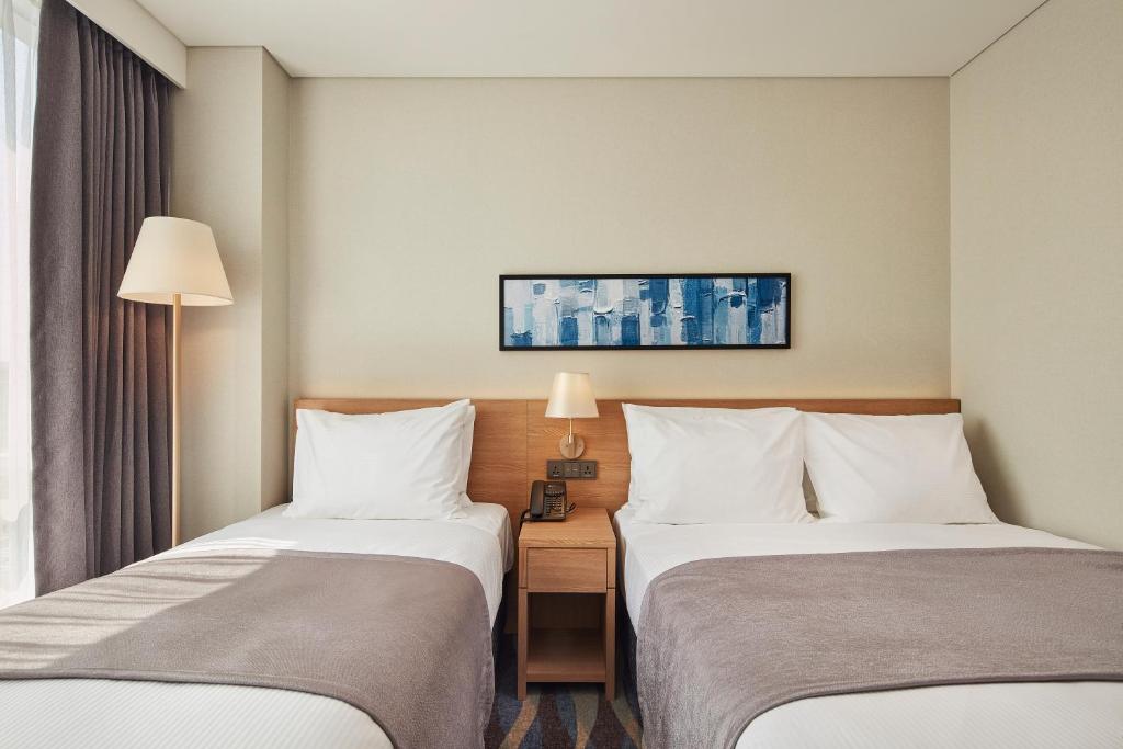 Postel nebo postele na pokoji v ubytování Ramada Encore by Wyndham Gimpo Han River Hotel
