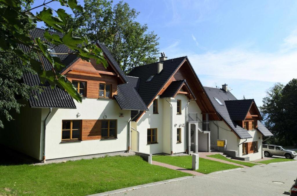 een wit huis met een zwart dak bij Domek Karpatka 2 przy wyciągu narciarskim in Karpacz