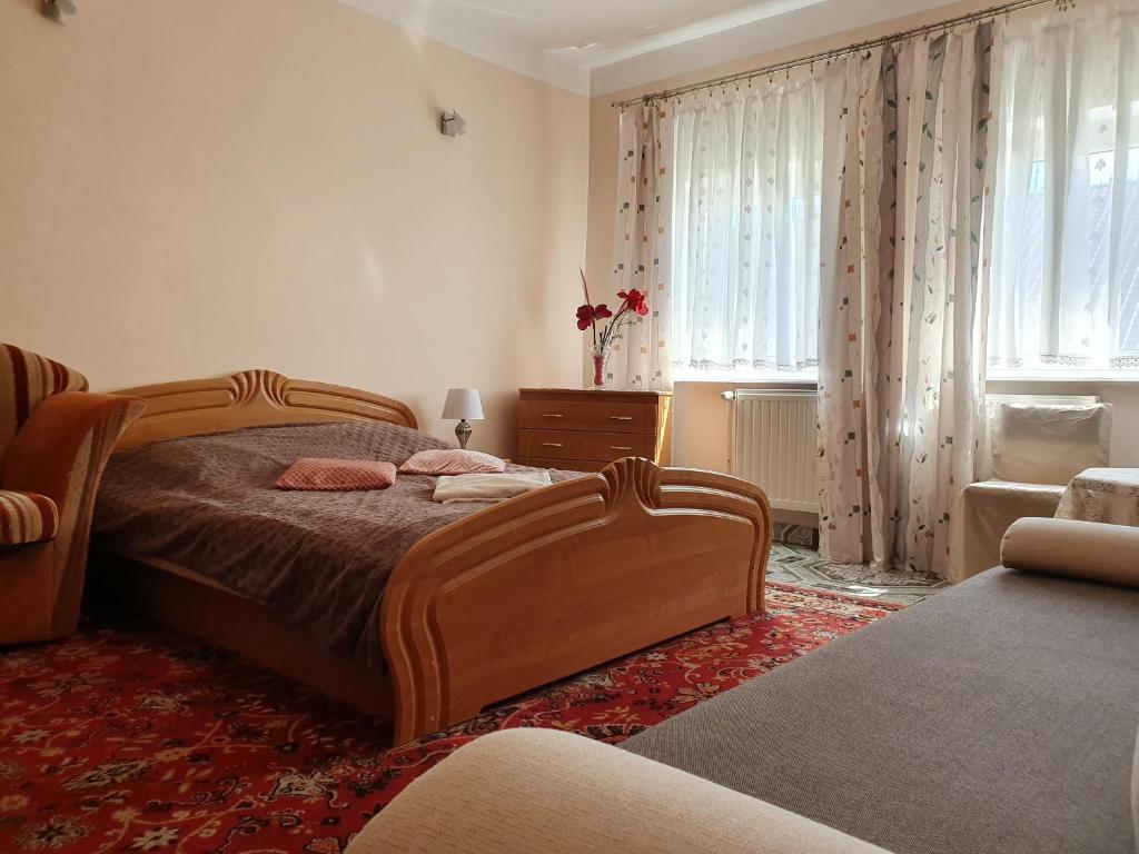 a bedroom with a bed and a chair and windows at Hotel Zaułek in Olszyna