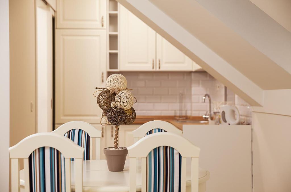 a kitchen with white cabinets and a table with chairs at Castello Boutique Hotel in Čačak