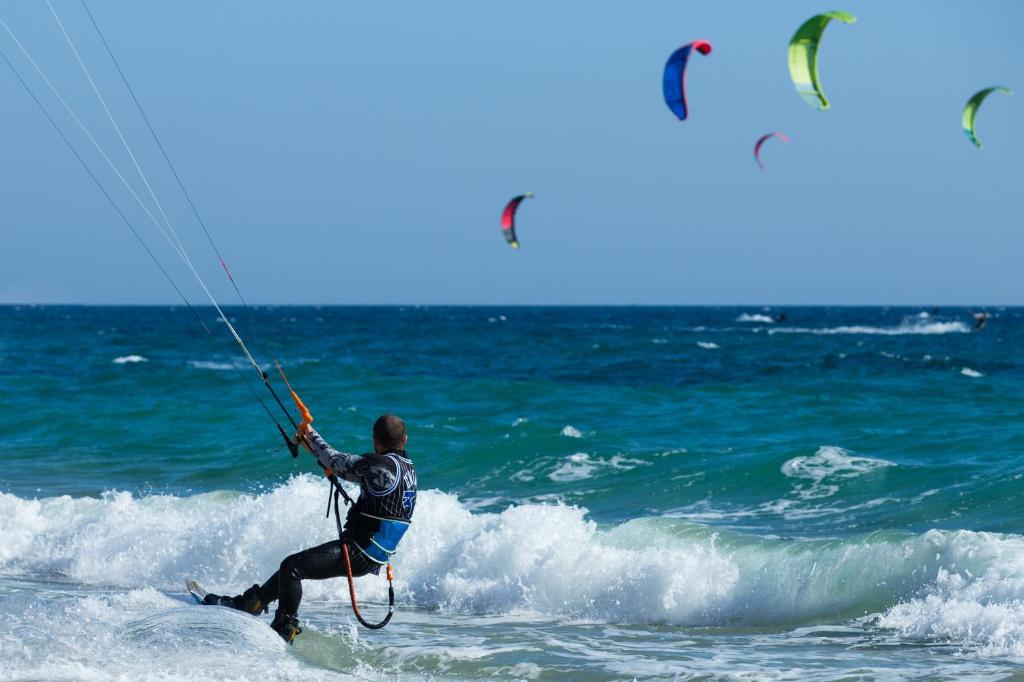 Um homem está a fazer kite-surf no oceano em Hotel Maravillas del Mundo em Calpe