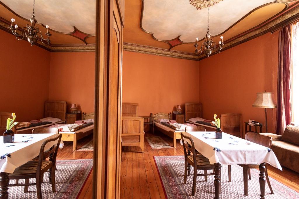 uma sala de jantar com mesas e cadeiras e um espelho em Hostel, Pokoje gościnne Mleczarnia - Ozonowane em Breslávia