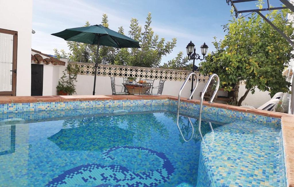 uma piscina com um guarda-sol ao lado de uma casa em El Algarrobo by CasaTuristica em Algatocín