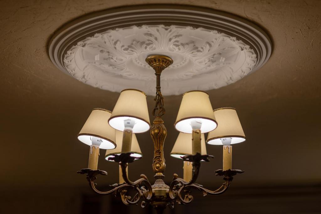 lampadario pendente appeso a un soffitto con lampadario pendente di Hôtel-Boutique Saint Louis a Lisieux