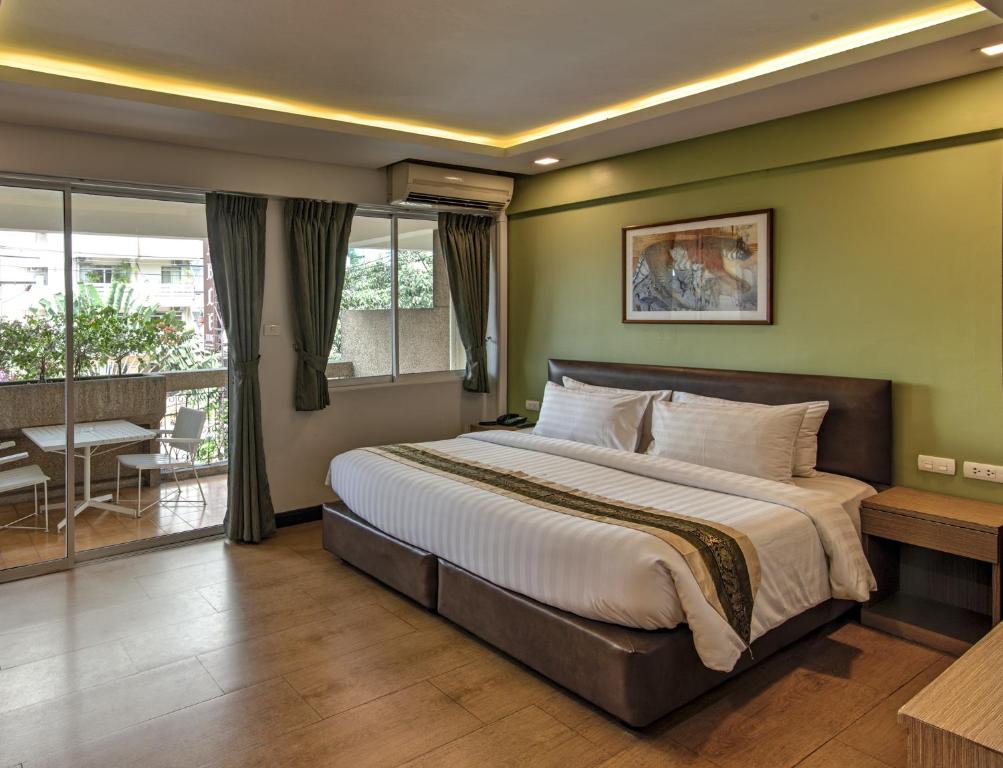 a bedroom with a large bed and a balcony at Stable Lodge - SHA Certified in Bangkok