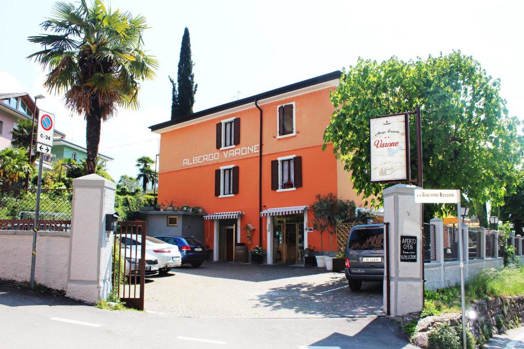 an orange building with cars parked in front of it at Albergo Varone in Riva del Garda