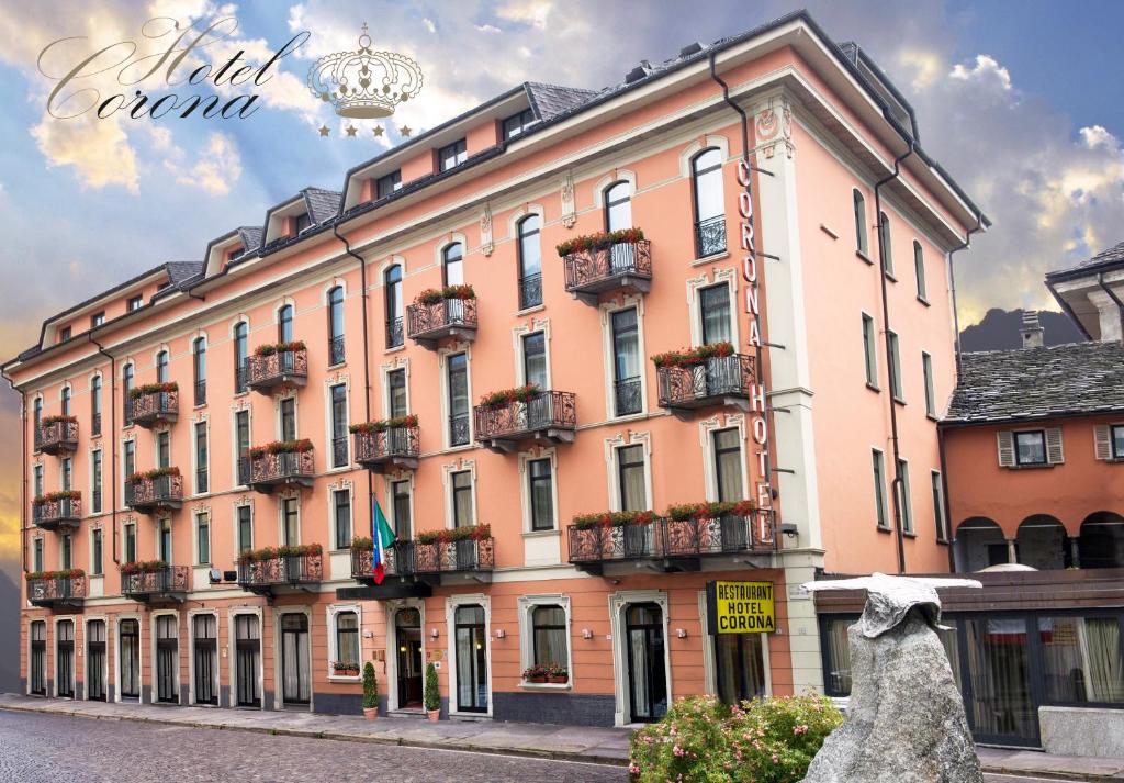 un grand bâtiment avec balcon dans une rue dans l'établissement Albergo Corona, à Domodossola