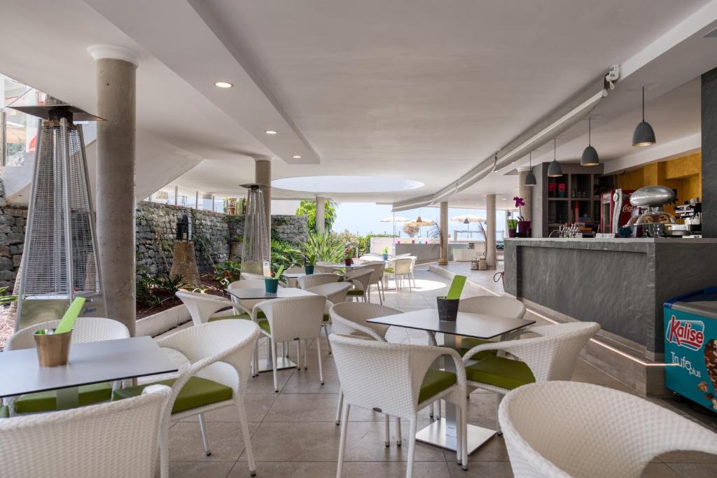 a restaurant with white tables and white chairs at Holiday Club Puerto Calma in Puerto Rico de Gran Canaria
