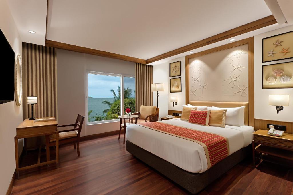 a hotel room with a bed and a desk and a window at Welcomhotel by ITC Hotels, Bay Island, Port Blair in Port Blair