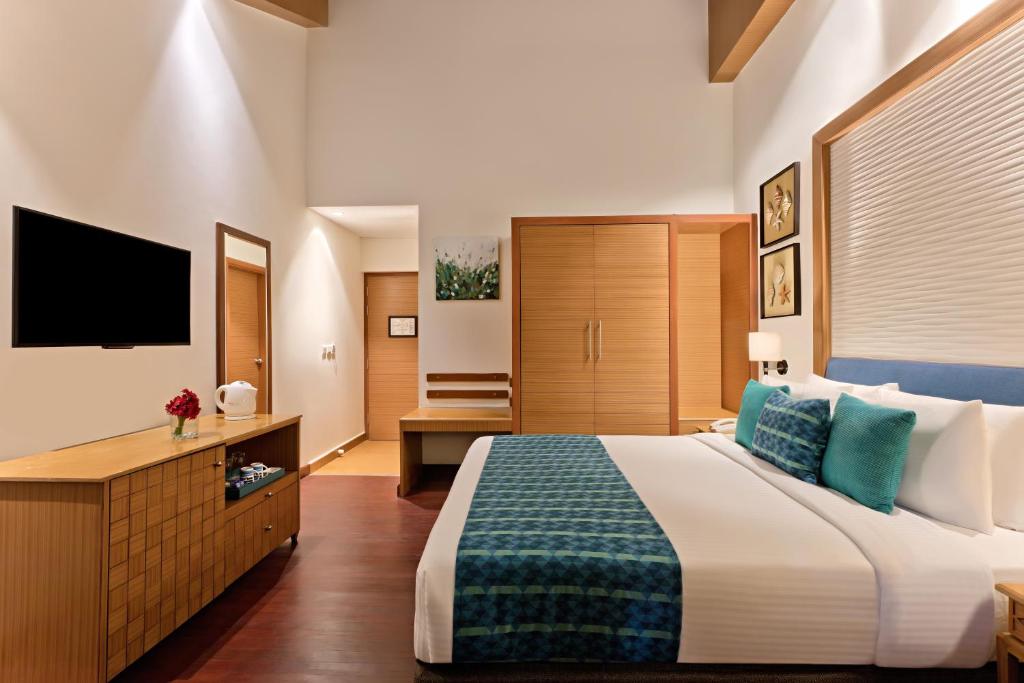 a hotel room with a large bed and a television at Welcomhotel by ITC Hotels, Bay Island, Port Blair in Port Blair