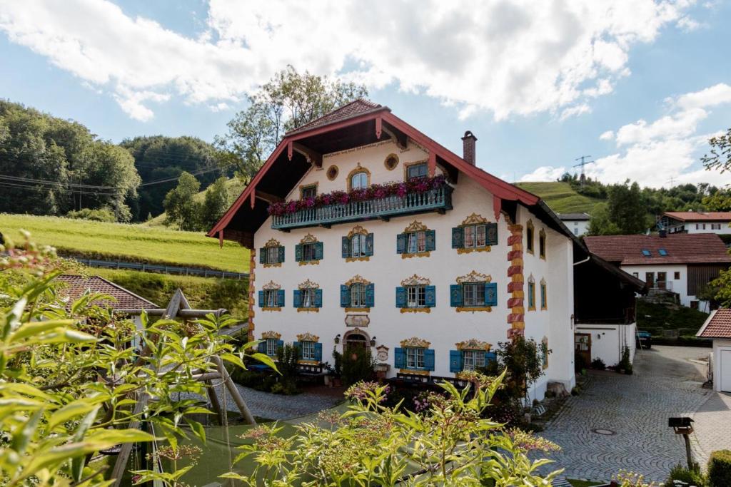 duży biały dom z czerwonym dachem w obiekcie Pension Ober w mieście Siegsdorf