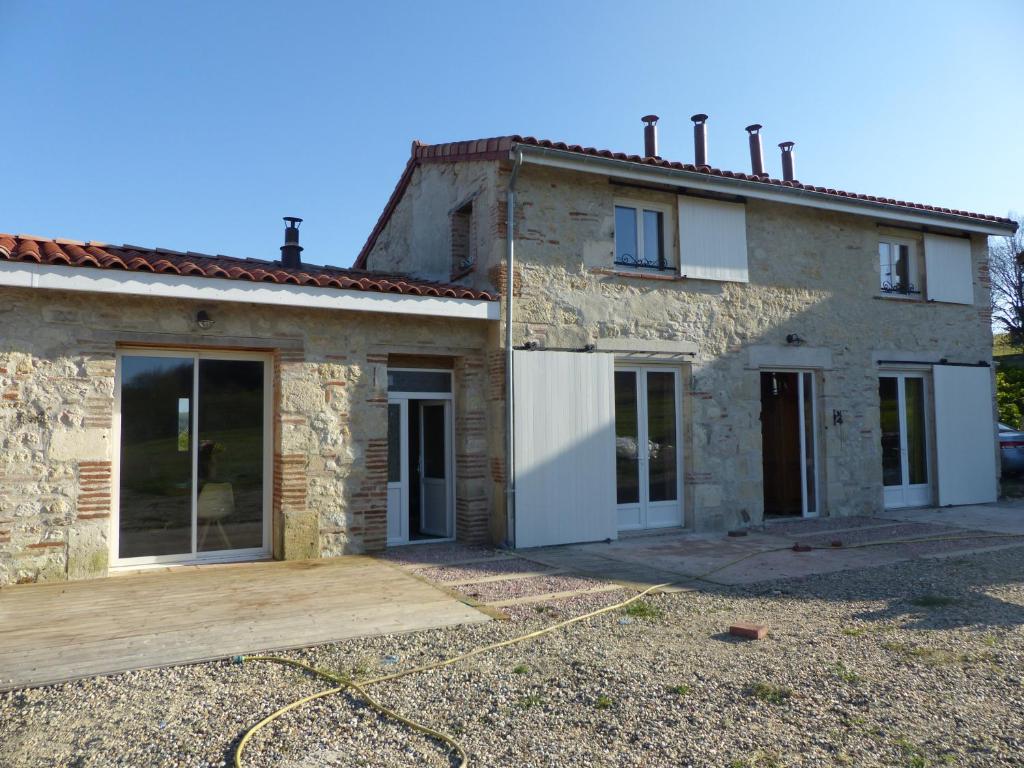 una casa in pietra con molte porte scorrevoli in vetro di Au Clair De Loup a Saint-Loup