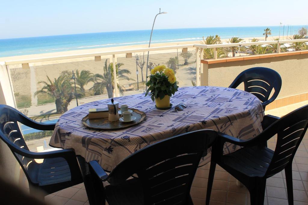 a table on a balcony with a view of the beach at Alba sul Mare in Alba Adriatica