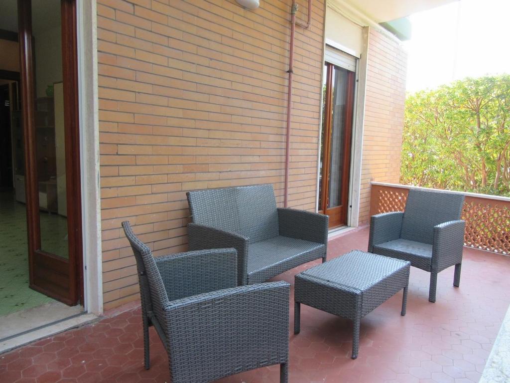 un gruppo di sedie e tavoli su un portico di Nicoletta's House - zona le dune - Porto Cesareo a Porto Cesareo