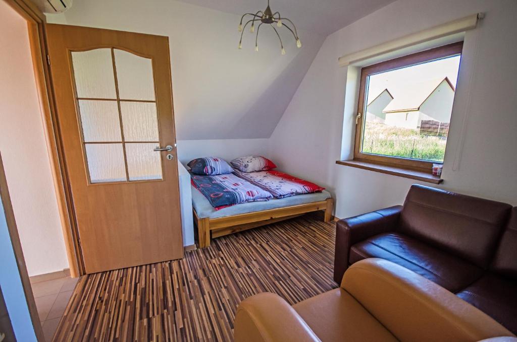 um pequeno quarto com uma porta, um sofá e uma janela em Domek Letniskowy Melon House em Gródek Nad Dunajcem