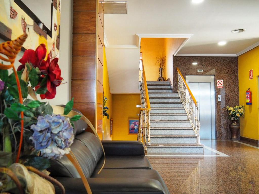 a lobby with a couch and stairs in a building at Hotel Humanes in Humanes de Madrid