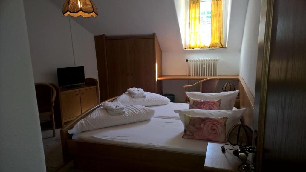 Schlafzimmer mit einem Bett mit weißer Bettwäsche und Kissen in der Unterkunft Hotel Monte Somma in Rüdesheim am Rhein