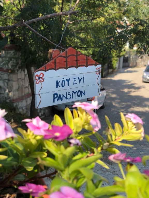 a sign for a koryevil plantation with pink flowers at KARABURUN KÖYEVİ Pansiyon in Saip