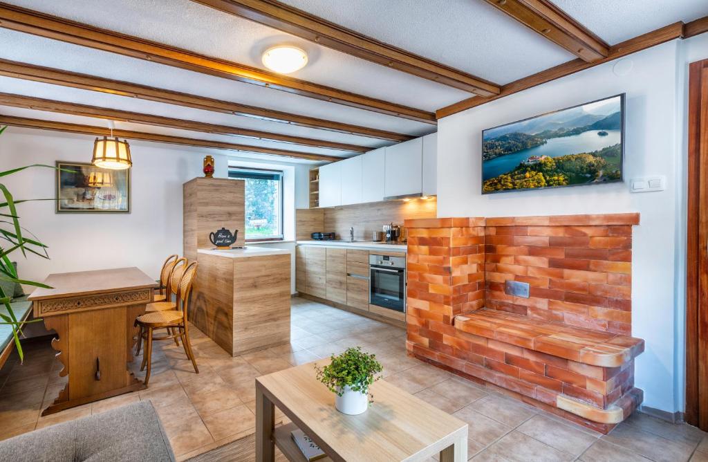 a kitchen with a brick fireplace and a table at Apartments Skodlar in Bled