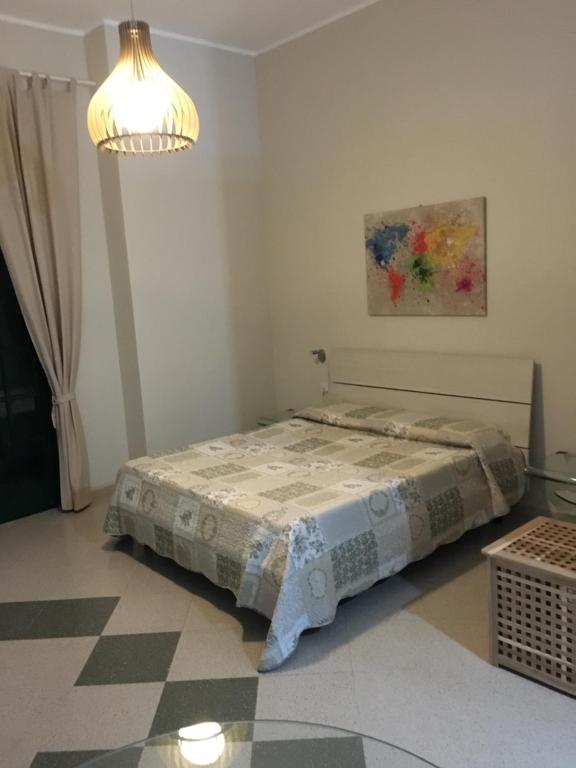 1 dormitorio con 1 cama en una habitación con lámpara en B&B Aliga, en Porto Empedocle
