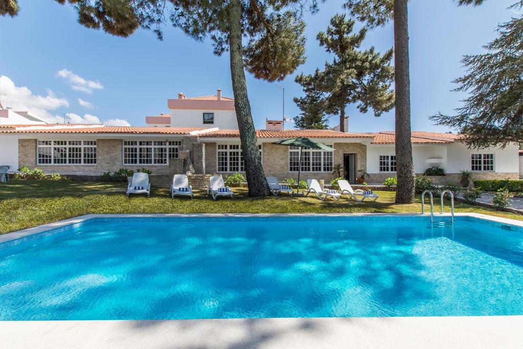 a swimming pool in front of a house at Villa Maia in Corroios