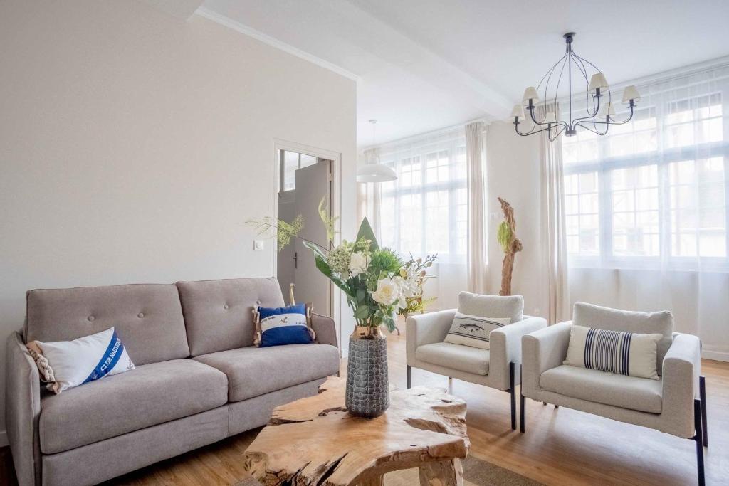 a living room with a couch and two chairs and a table at Elégant appartement en plein coeur de Cabourg - Les locations de Proust in Cabourg