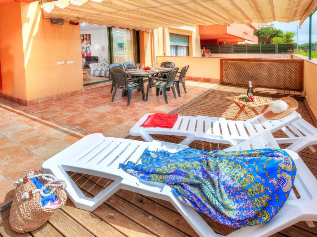 a group of white picnic tables and chairs on a patio at Apartment Gardenia by Interhome in Lloret de Mar