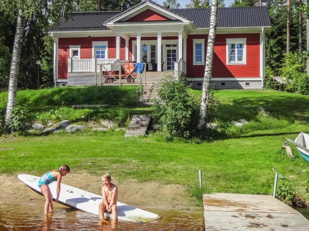 dos chicas en el agua frente a una casa en Holiday Home Villa elisabet by Interhome, en Löytö