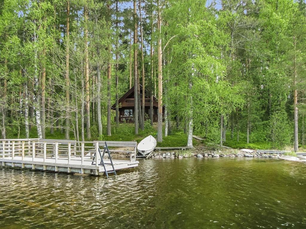 une cabine sur un lac avec un quai et un bateau dans l'établissement Holiday Home Auringonlasku by Interhome, à Hirvikoski