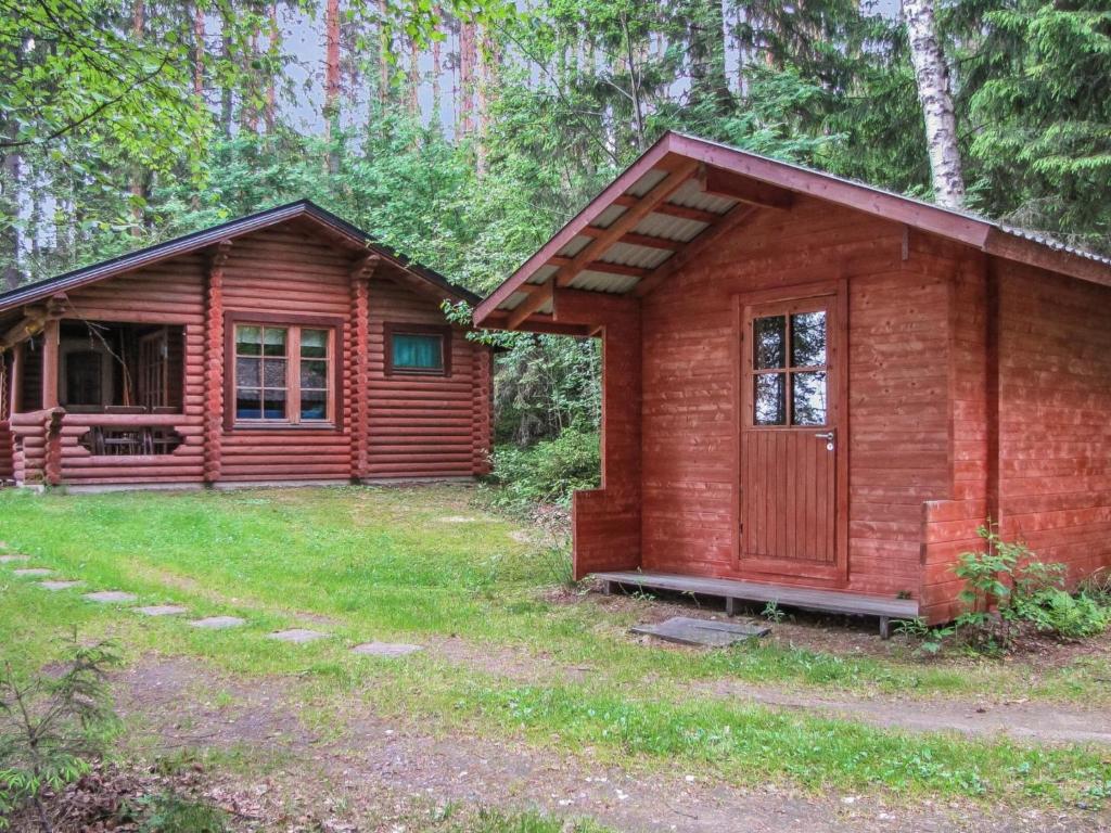 a wooden cabin in the middle of a forest at Holiday Home Länsiranta by Interhome in Hirvikoski