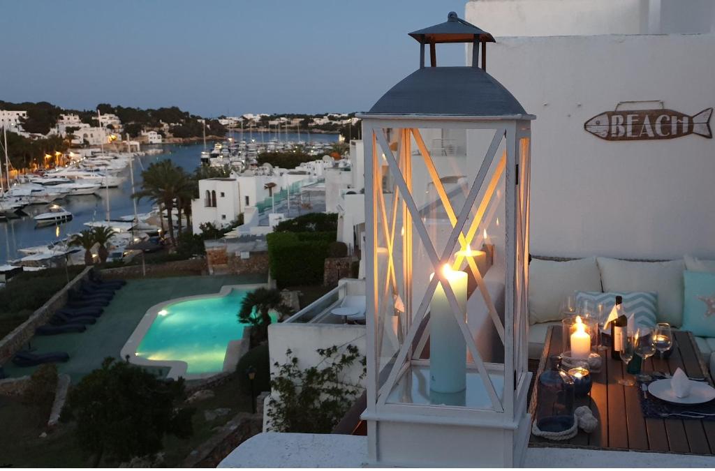 a lantern on a balcony with a view of a pool at APARTMENT MARINA CALADOR HARBOURVIEW AIR CONDITION POOL GARDEN TERRASSE PORTO CARI spectacular locatio in Cala d´Or
