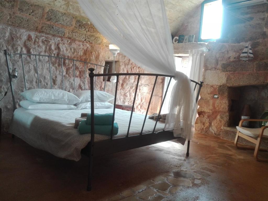 een slaapkamer met een bed in een bakstenen muur bij Trullo Nicola in Castrignano del Capo