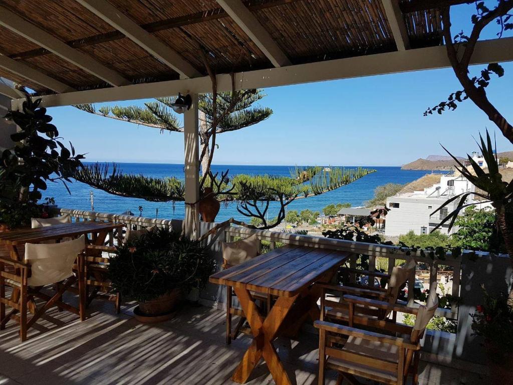a patio with tables and chairs and a view of the ocean at Villa Tsapakis in Lentas