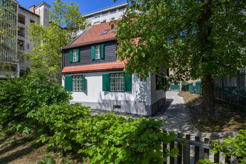 uma casa com persianas verdes numa rua em Vila Selena em Liubliana