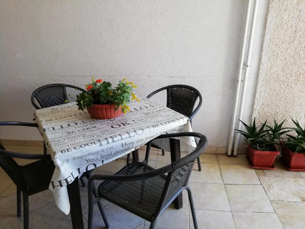 stół z krzesłami i stół z kwiatami w obiekcie Apartments Jadranka Ivana Pula w Puli