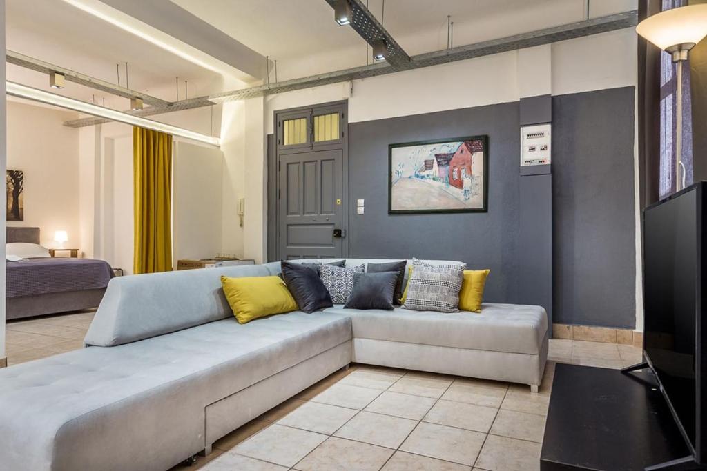 sala de estar con sofá gris y almohadas amarillas en Renovated Loft At the Center of Monastiraki en Athens