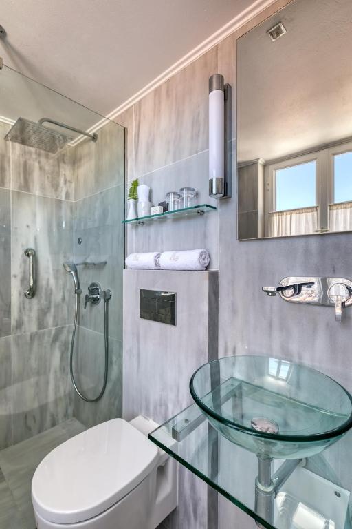 bagno con lavabo in vetro e servizi igienici di Hotel Leto Hydra a Hydra