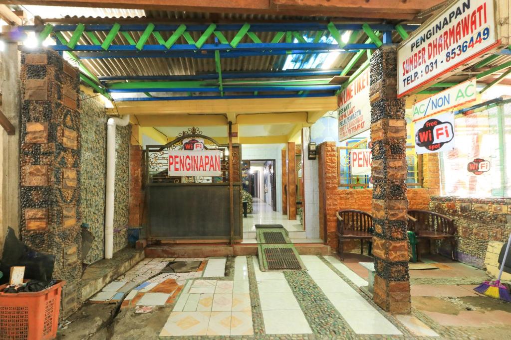 Zugang zu einem Restaurant mit einem Schild an der Wand in der Unterkunft Dharmawati Homestay Syariah at Terminal Purabaya in Waru