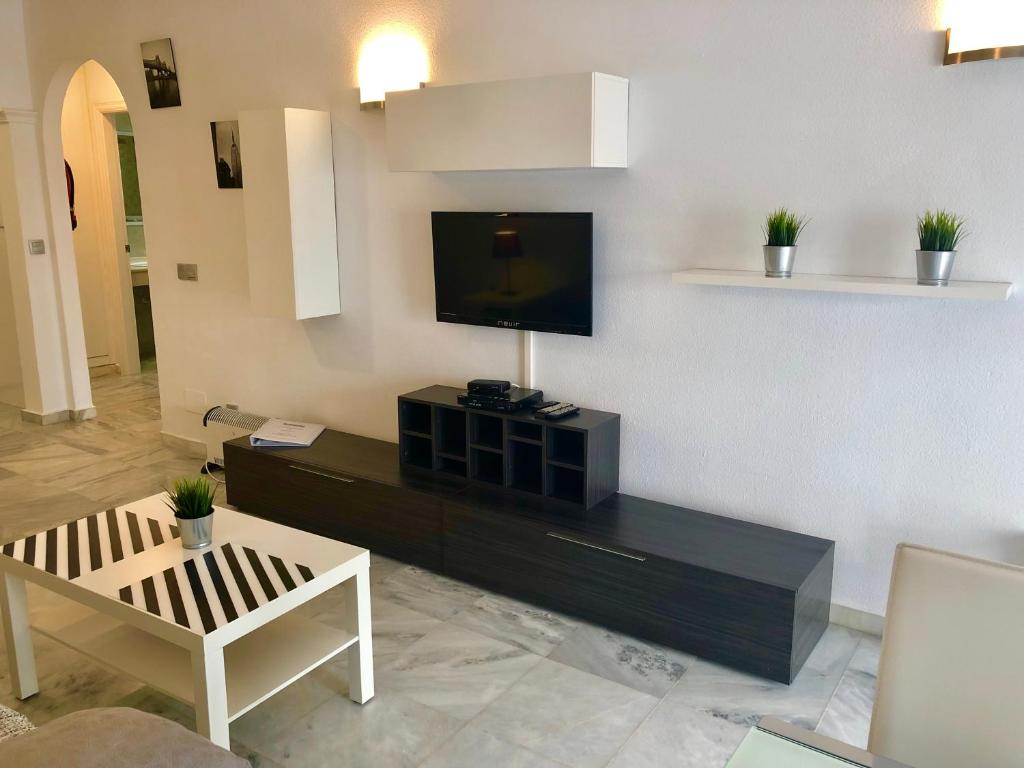 a living room with a flat screen tv on a wall at Apartamentos Las Rosas de Capistrano in Nerja