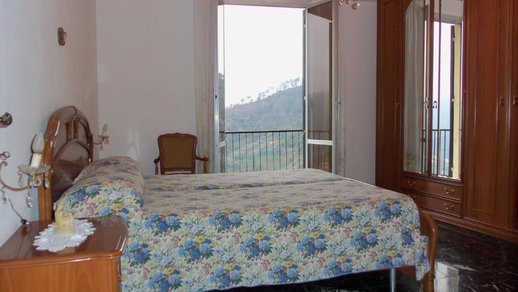 um quarto com uma cama e uma grande janela em Luna Rossa da Nadia em Levanto