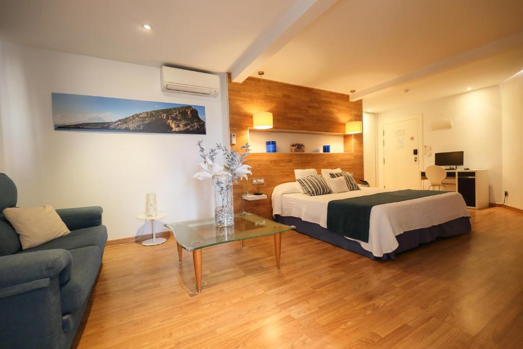 1 dormitorio con 1 cama y sala de estar con sofá en Hotel Fetiche Alojamiento con Encanto, en Benidorm