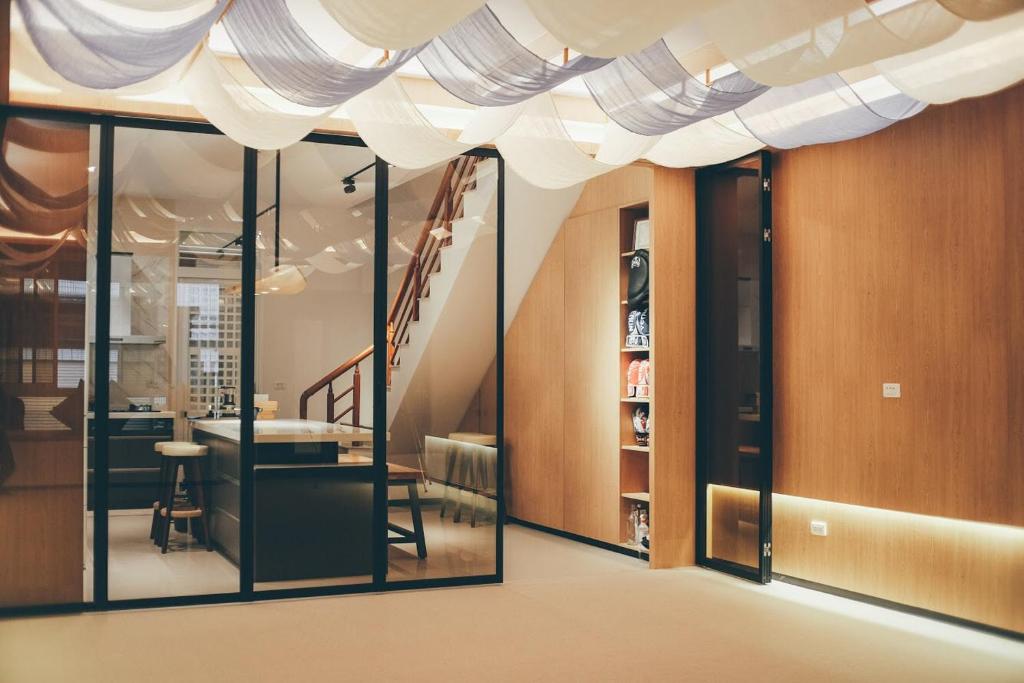 una camera con porte scorrevoli in vetro e una scala di Lounge away a Città di Taitung