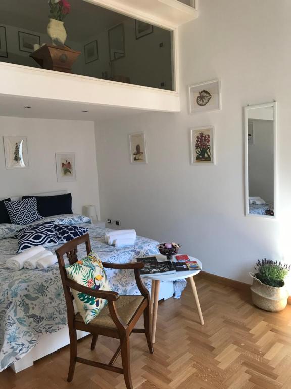 ein Schlafzimmer mit einem Bett, einem Tisch und einem Stuhl in der Unterkunft Ella's Home in Neapel