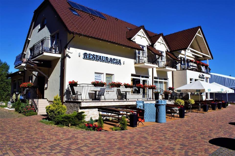 a building with benches and tables in front of it at Dom Bursztynowy in Jantar