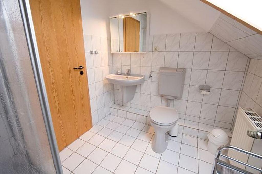 ein weißes Bad mit einem WC und einem Waschbecken in der Unterkunft Haus Panorama Sankt Andreasberg in Sankt Andreasberg