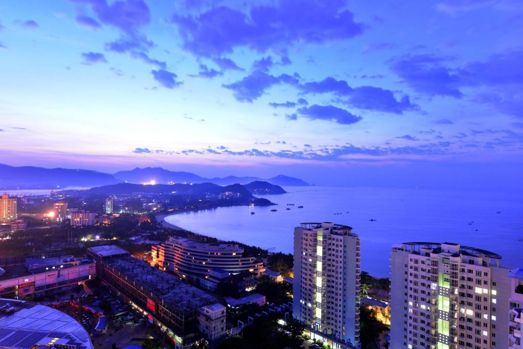 a city with a view of the ocean at night at Barry Boutique Hotel Sanya in Sanya