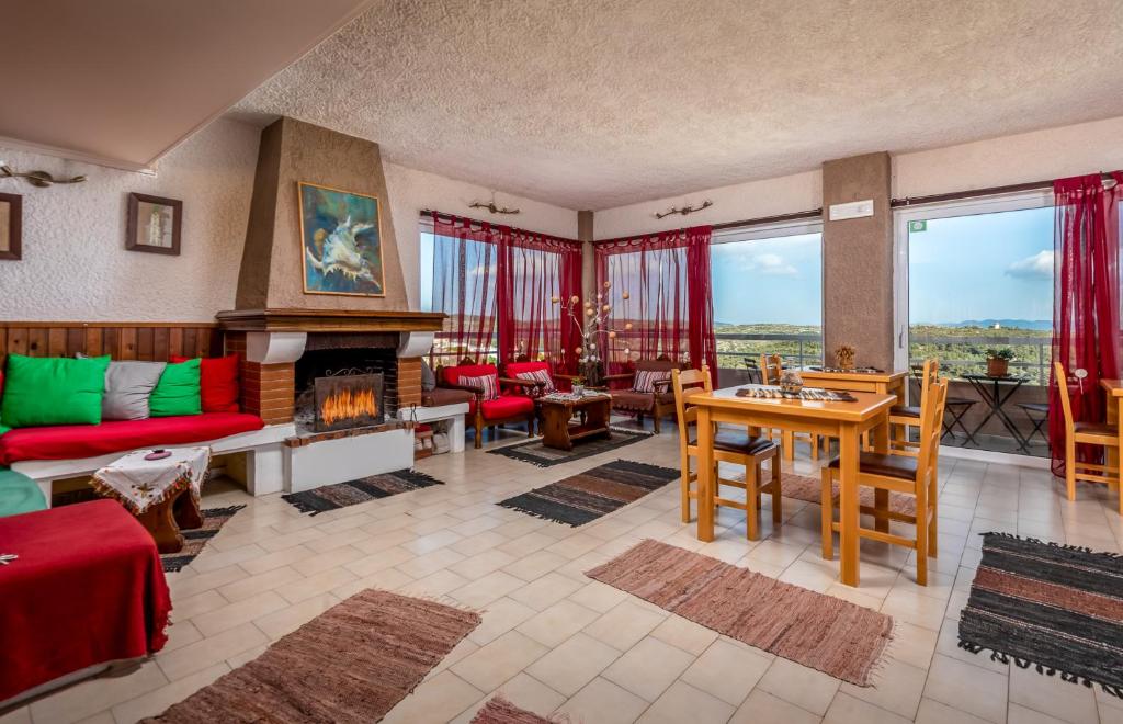 a living room with a fireplace and a red couch at Thomas Hotel in Monólithos