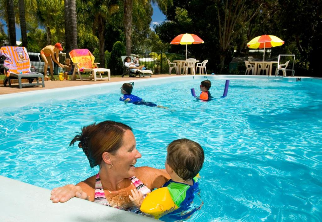a woman and a baby in a swimming pool at Acclaim Kingsway Tourist Park in Perth
