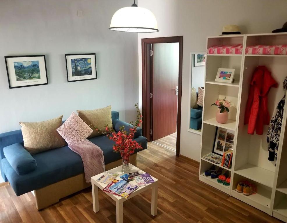 uma sala de estar com um sofá azul e uma mesa em Plovdiv Top Center 2 Bdrm Apartment, 5min from Central Square & Garden, FREE Parking em Plovdiv