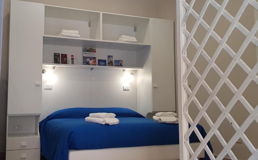 アグローポリにあるM & Mのベッドルーム1室(青いベッド1台、棚、タオル付)